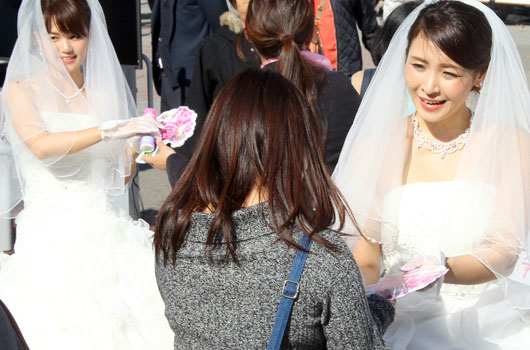 横浜・桜木町駅前広場、ウエディングドレスの美女が『アロエステ』サンプリング！「おっさん肌」に警鐘